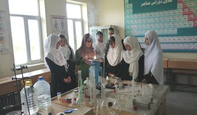 Photo from Afghnaischer Frauenverein showes women at scholl doing chemistry